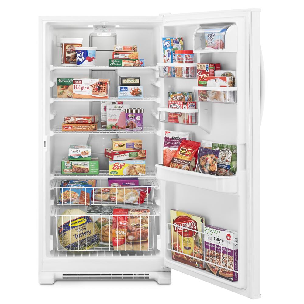 Open white upright freezer filled with frozen foods and organized wire baskets in kitchen appliances collection