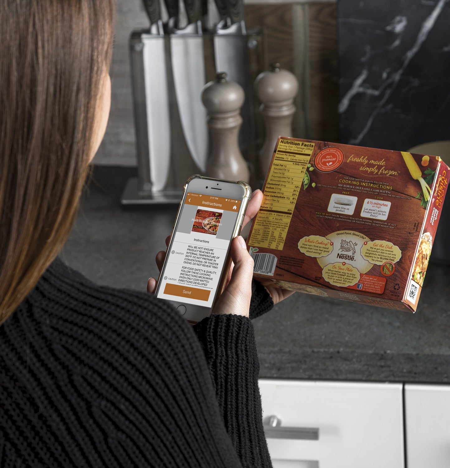 Person scanning cooking instructions from a frozen meal box using a smartphone in a modern kitchen setting