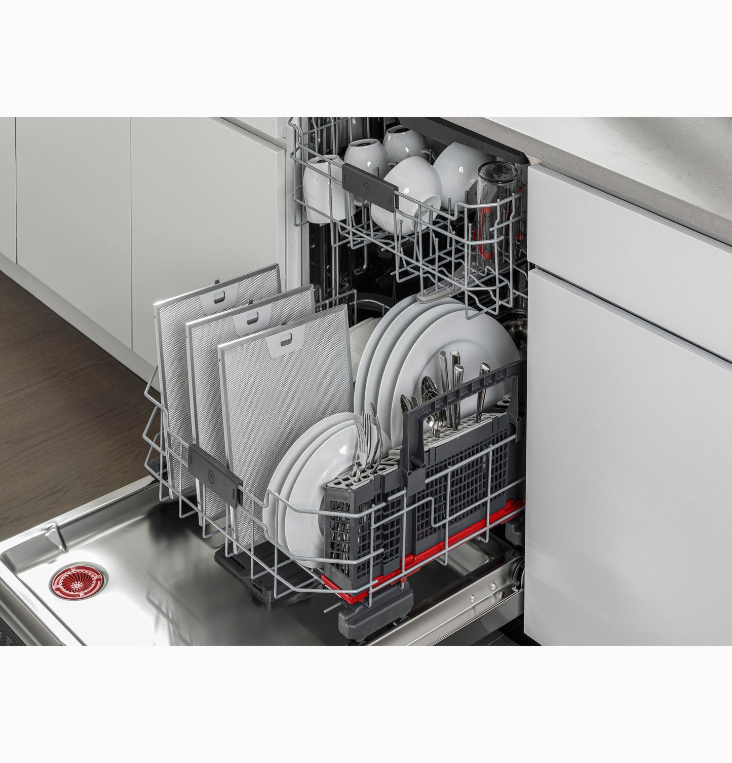 Open dishwasher with neatly arranged white plates, cups, silverware, and dishwasher filters inside modern kitchen appliances collection