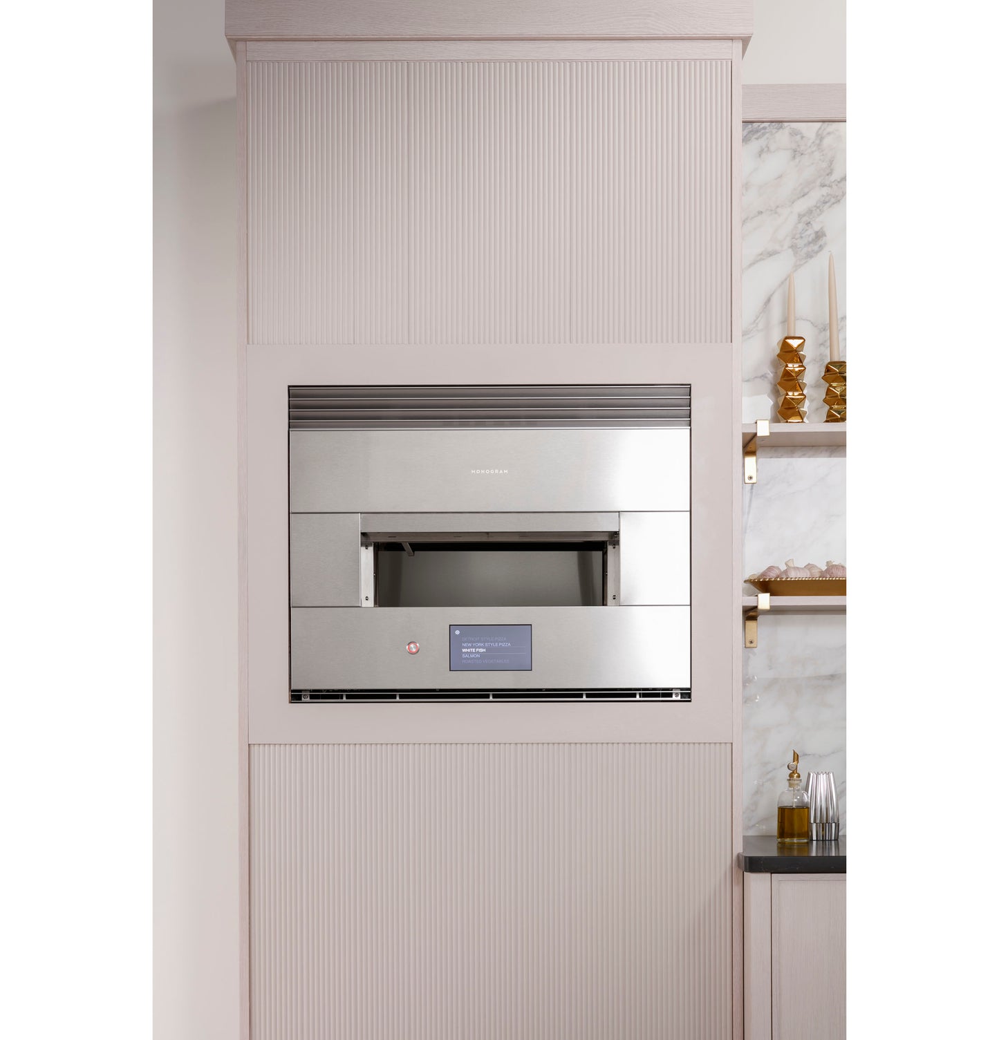 Stainless steel built-in wall oven with digital display, installed in a modern kitchen with marble accents and shelves