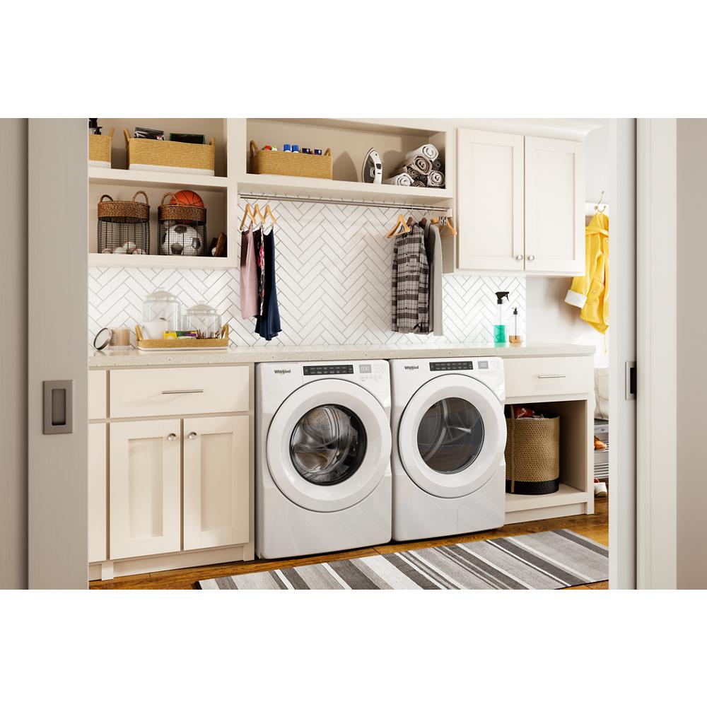 White front load washer and matching heat pump dryer set in modern laundry room with cabinetry and shelving
