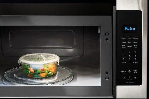 Stainless steel over-the-range microwave with digital keypad and sensor cooking technology heating vegetables inside