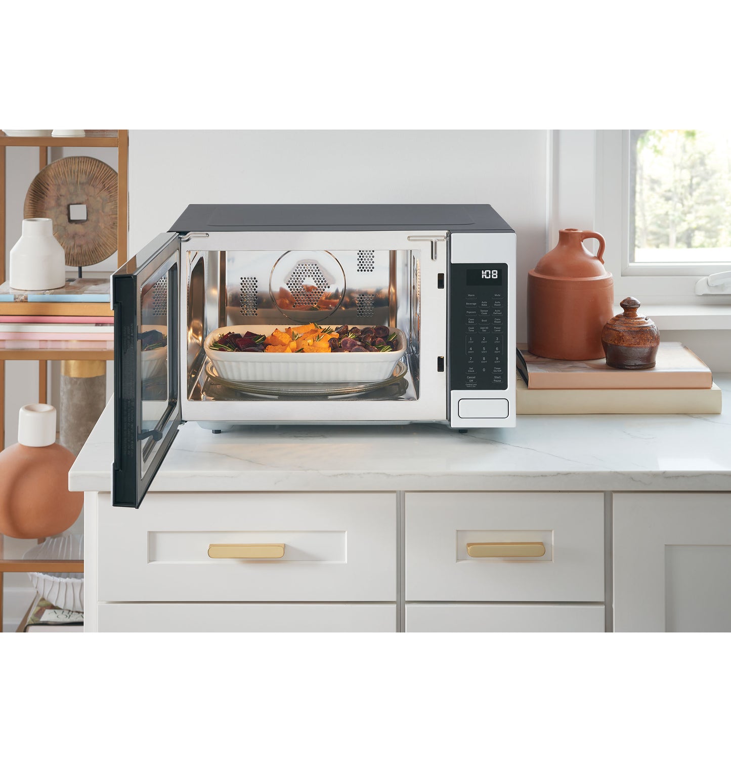 Smart countertop convection microwave oven with open door and casserole dish inside on kitchen counter