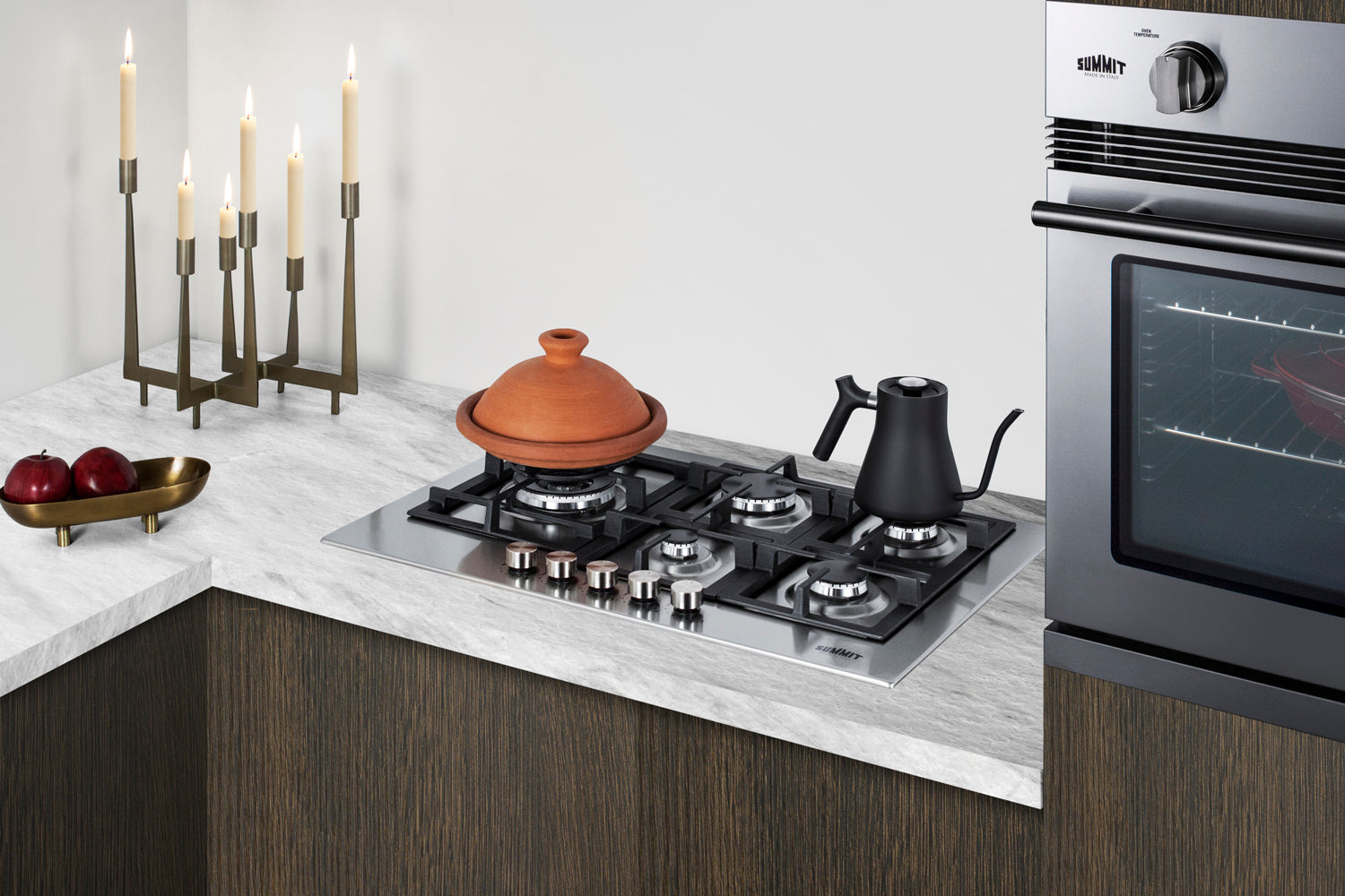 Modern kitchen corner with a built-in 30" wide gas cooktop and stainless steel wall oven in dark wood cabinetry