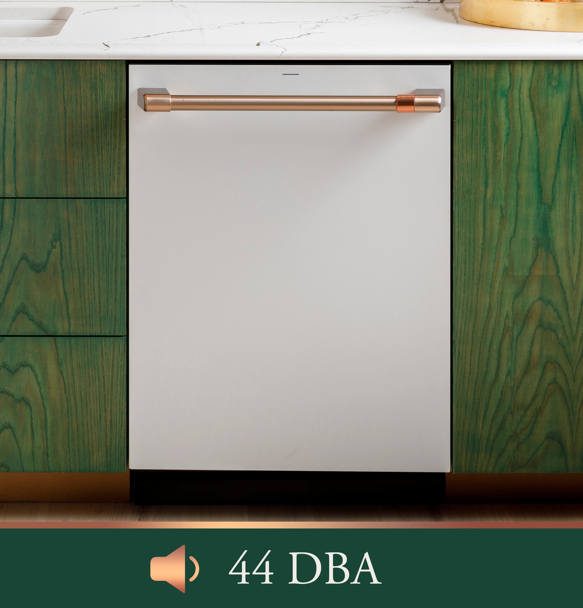 Built-in stainless steel dishwasher with copper-tone handle integrated into green cabinetry under marble countertop.