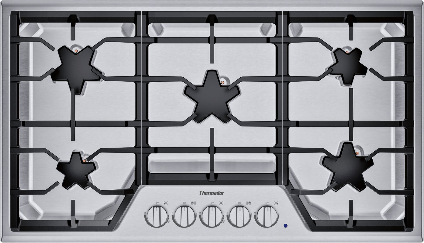 Stainless steel 36-inch gas cooktop with five burners, continuous grates, and front control knobs in kitchen appliances collection