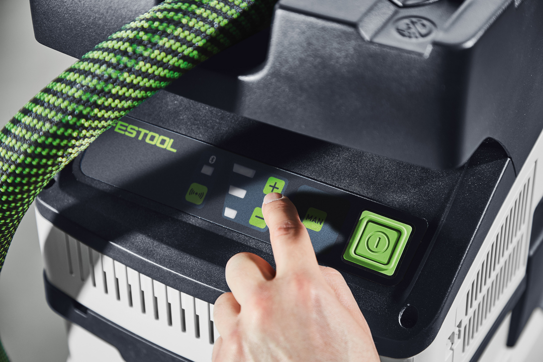 User pressing plus button on cordless Festool HEPA mobile dust extractor control panel in woodworking tools category