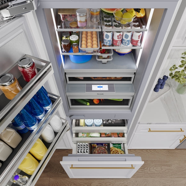 Open built-in bottom freezer refrigerator with organized shelves and drawers stocked with various food and beverage items