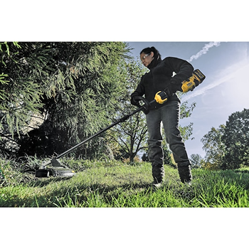 Person using a cordless yellow and black brushless string trimmer outdoors for lawn maintenance and home improvement