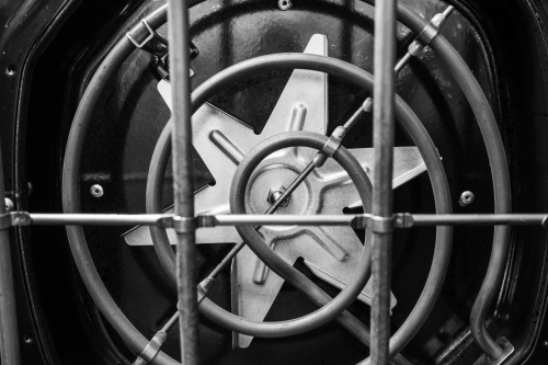 Close-up view of circular oven burner and metal safety grid inside kitchen range in Ranges at Hartville Hardware
