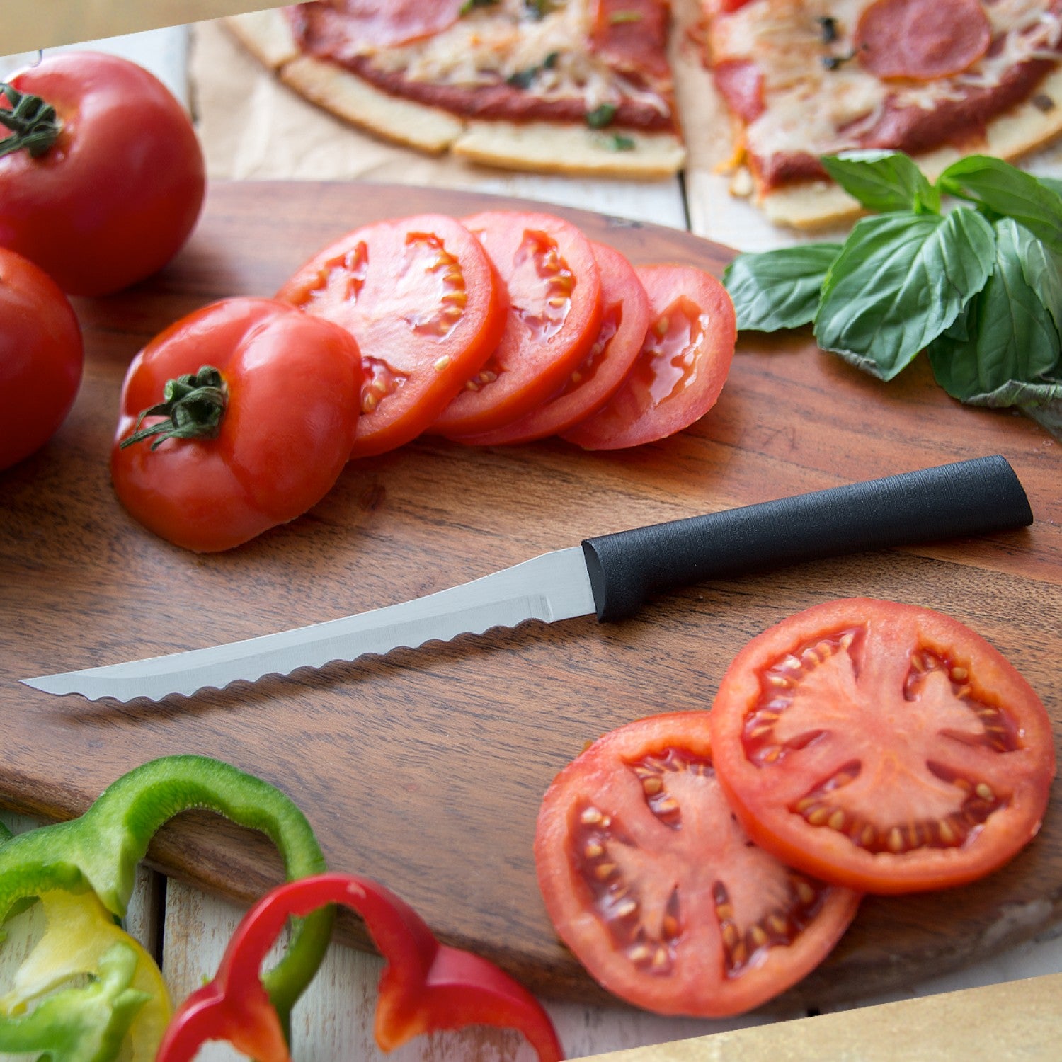 Serrated tomato slicer with black handle cutting fresh tomato slices on wooden board in kitchen utensils under $50 collection