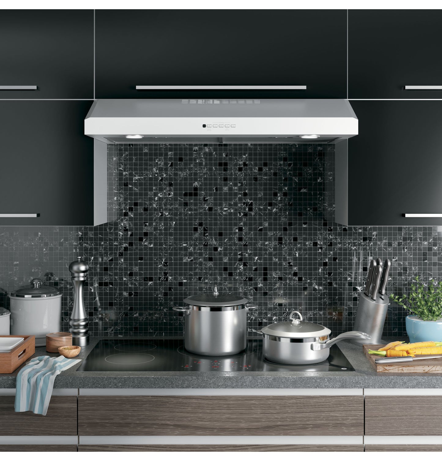 Modern stainless steel under cabinet range hood with built-in lights over stove in a contemporary kitchen setting