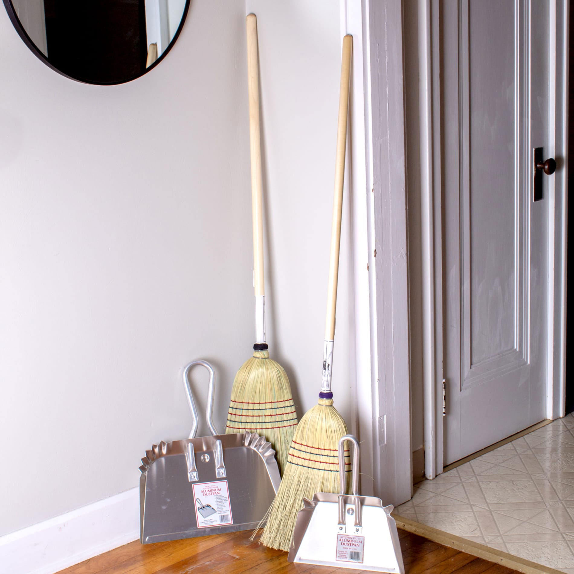 Set of two wooden-handle brooms paired with metal dustpans for efficient dust collection in home improvement and woodworking tools.
