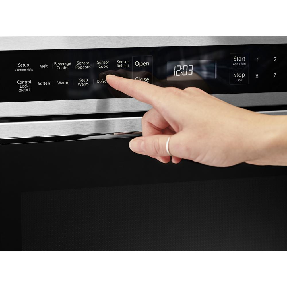 Hand pressing sensor cook button on stainless steel microwave oven drawer digital control panel from KitchenAid collection