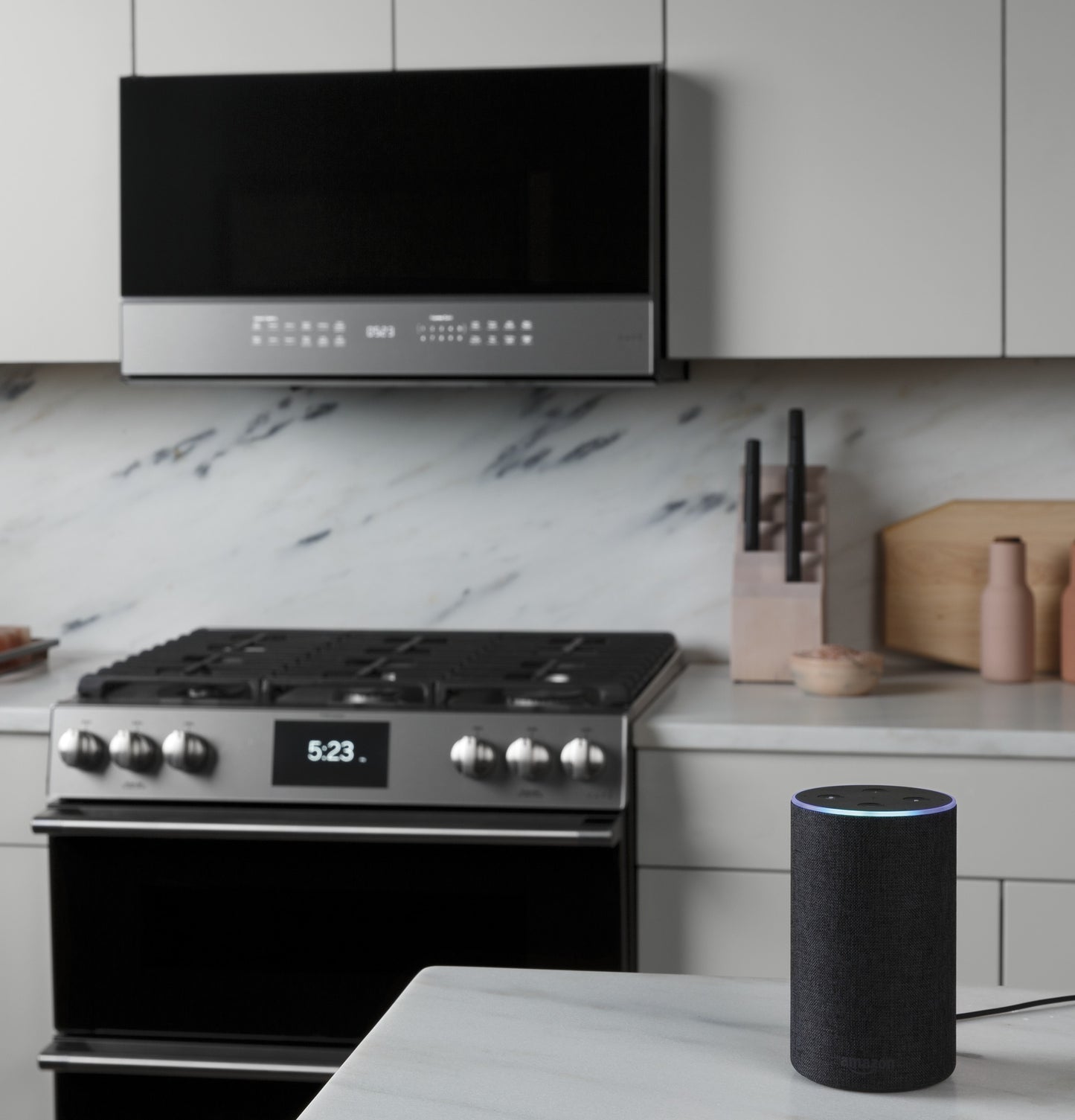 Smart over-the-range microwave with platinum glass and digital display above stainless steel gas range in modern kitchen