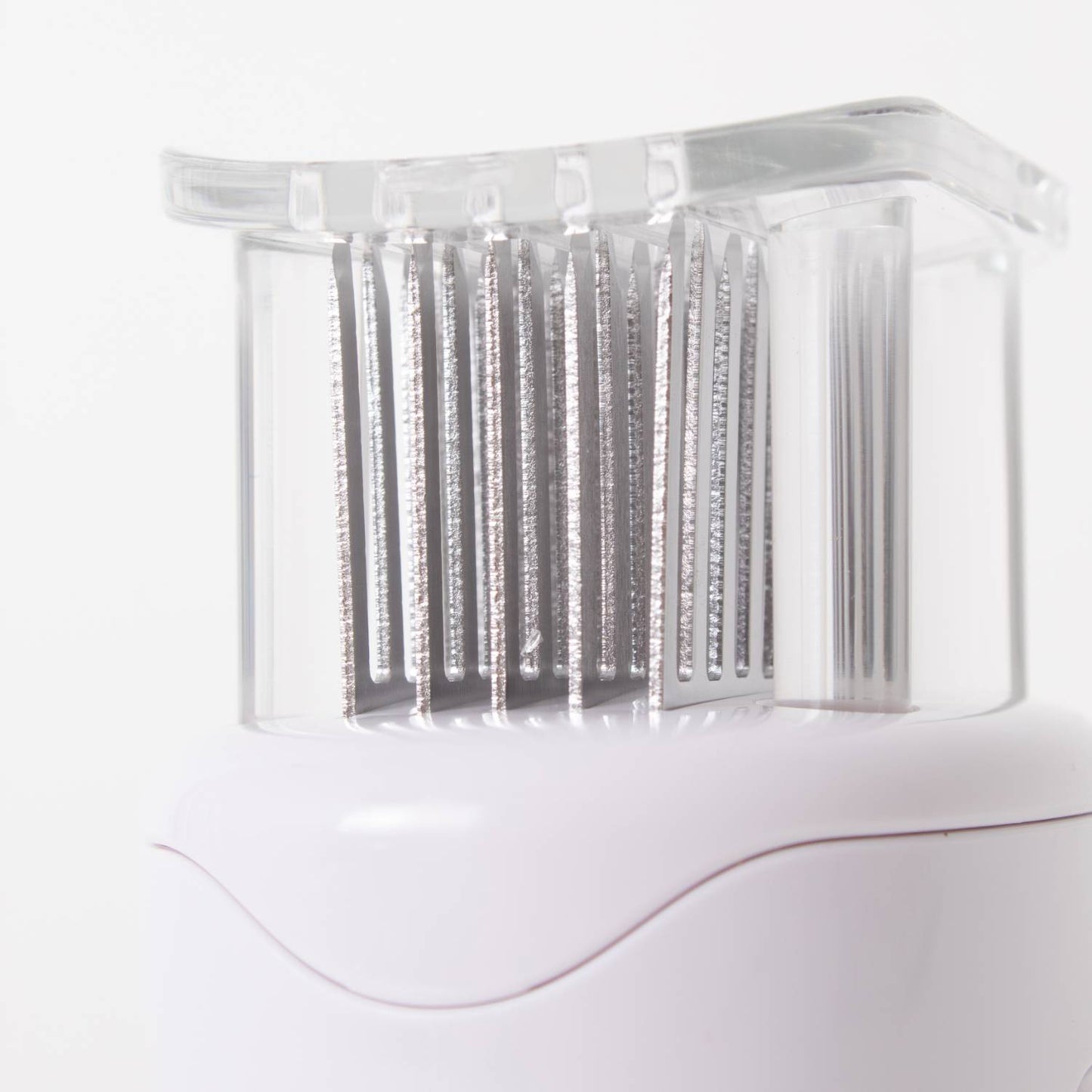 Close-up of sharp blades on a clear and white kitchen utensil for tenderizing meat in cooking utensils collections under $50