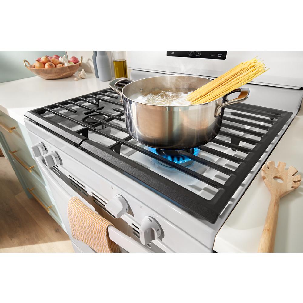 White gas range with cast iron grates and boiling pasta in stainless pot, part of kitchen appliance and home improvement collection