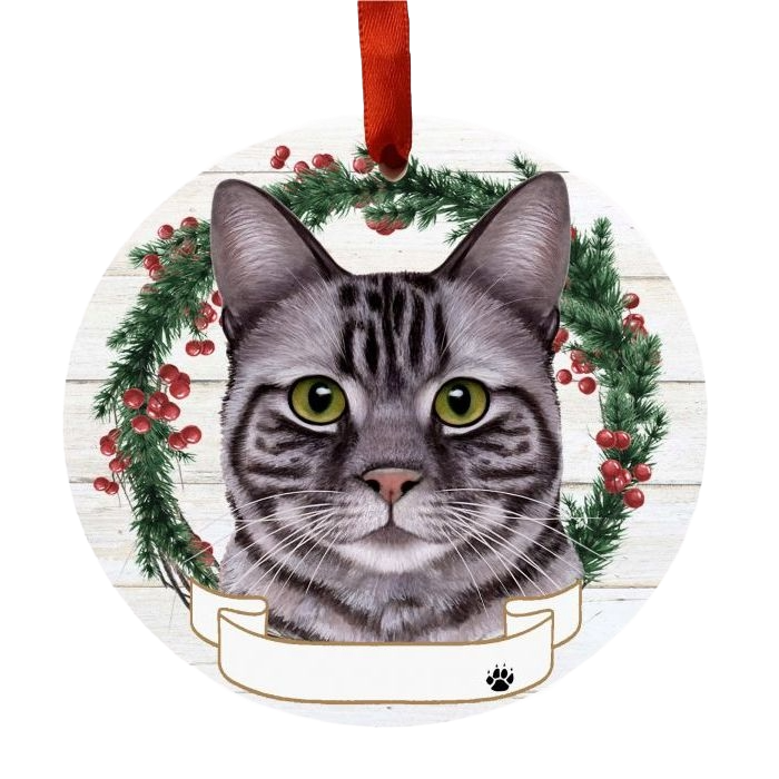 Round Christmas ornament featuring a silver tabby cat face with festive wreath and red ribbon hanger