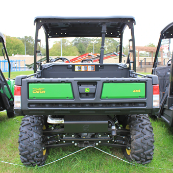 Rear view of a green full-size utility vehicle with rugged tires and brush guard for outdoor and home improvement tasks