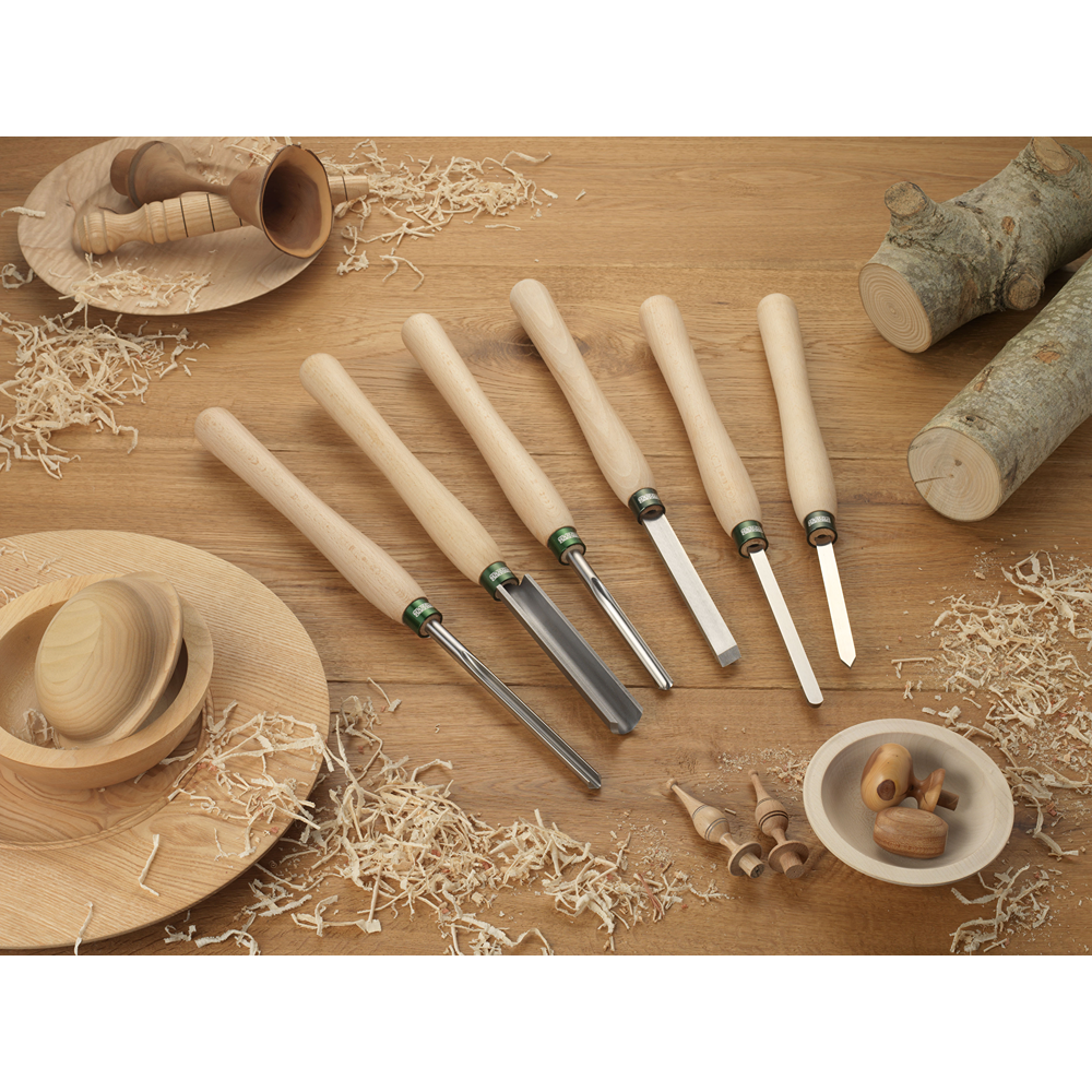 Six-piece woodturning tool set with 12-inch beech handles surrounded by wood shavings and turned wood pieces