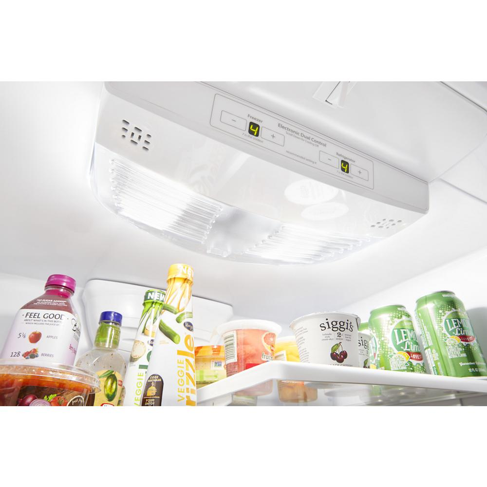 Interior view of refrigerator shelf with beverages and dairy containers under bright LED lighting and digital controls