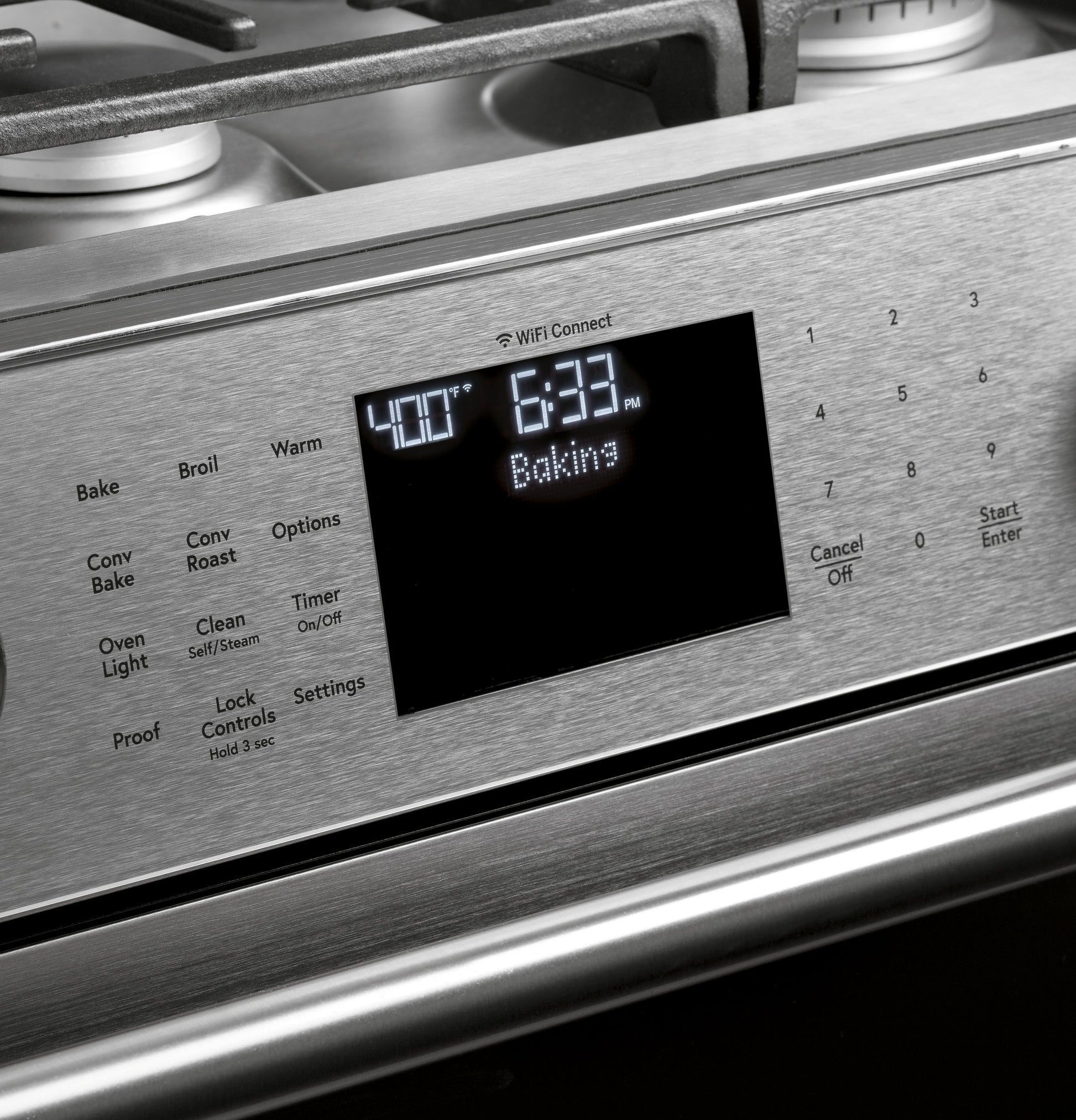 Close-up of stainless steel smart gas range control panel with digital display and touchscreen controls for baking timer