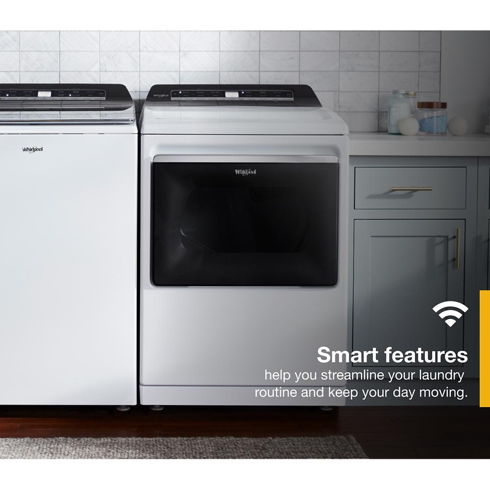 White top load electric dryer with dark tinted glass door and digital controls in modern laundry space with cabinetry