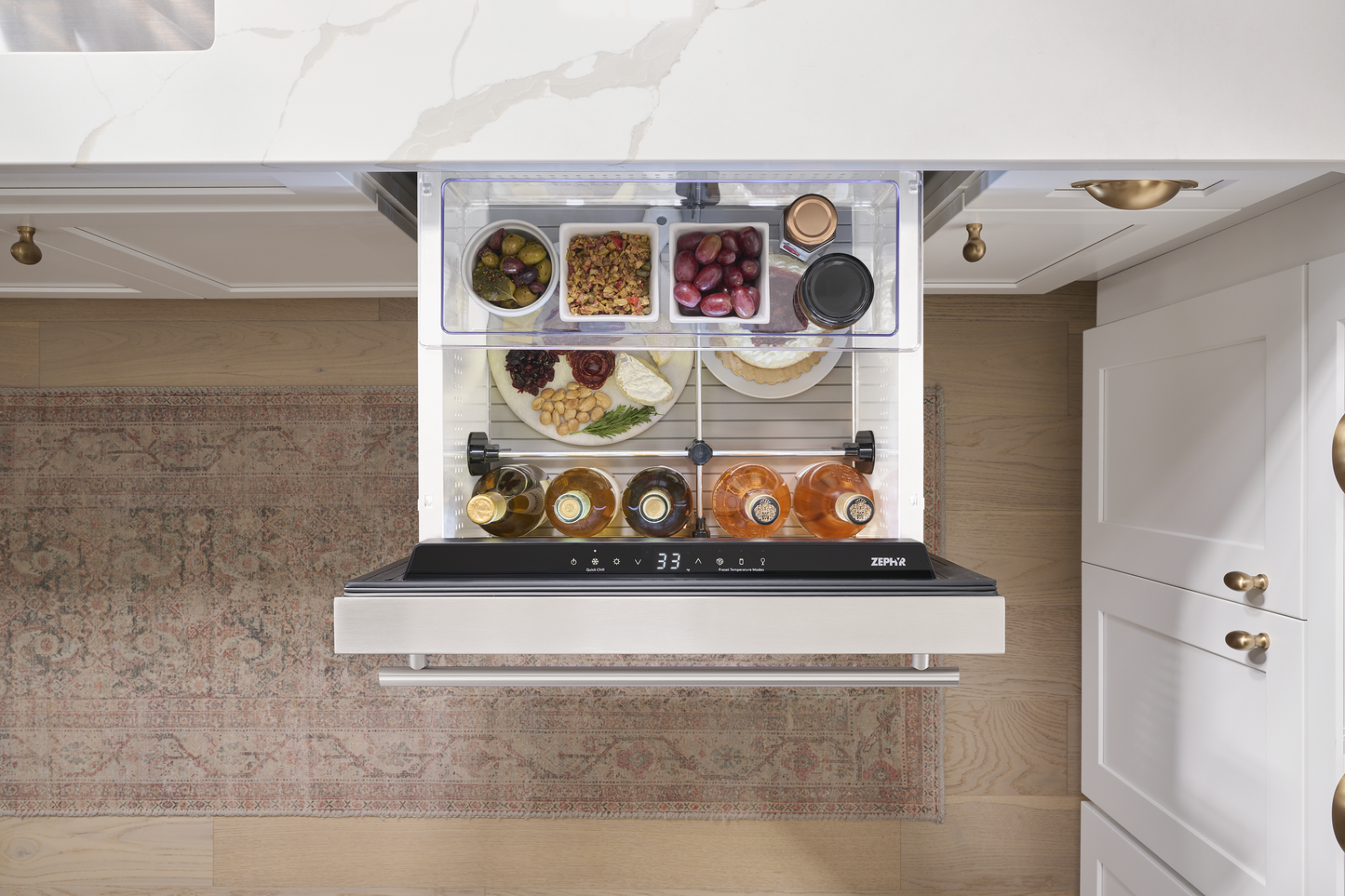 Under-counter stainless steel single zone refrigerator drawer with beverages, snacks, and fresh produce in modern kitchen setting