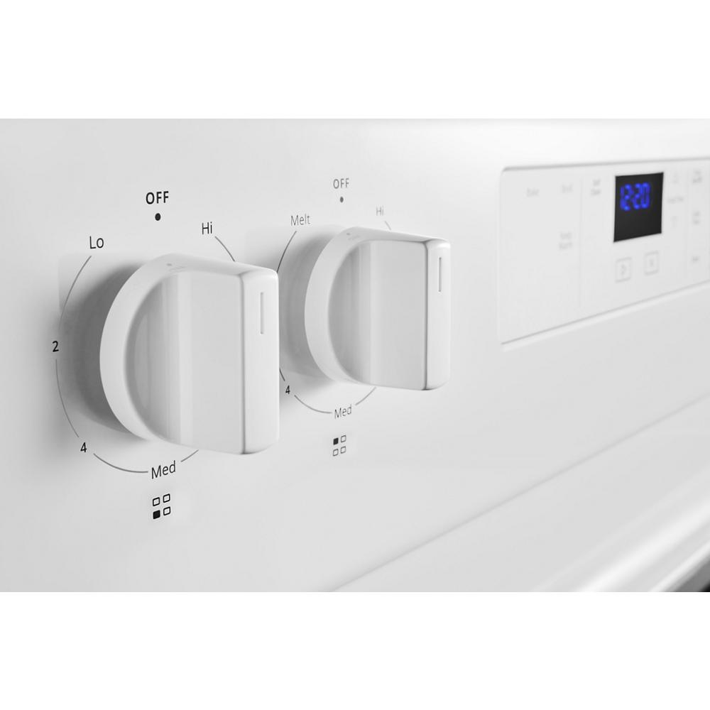 Close-up of white control knobs for burner heat settings and digital display on electric range from Ranges & Cooktops collection