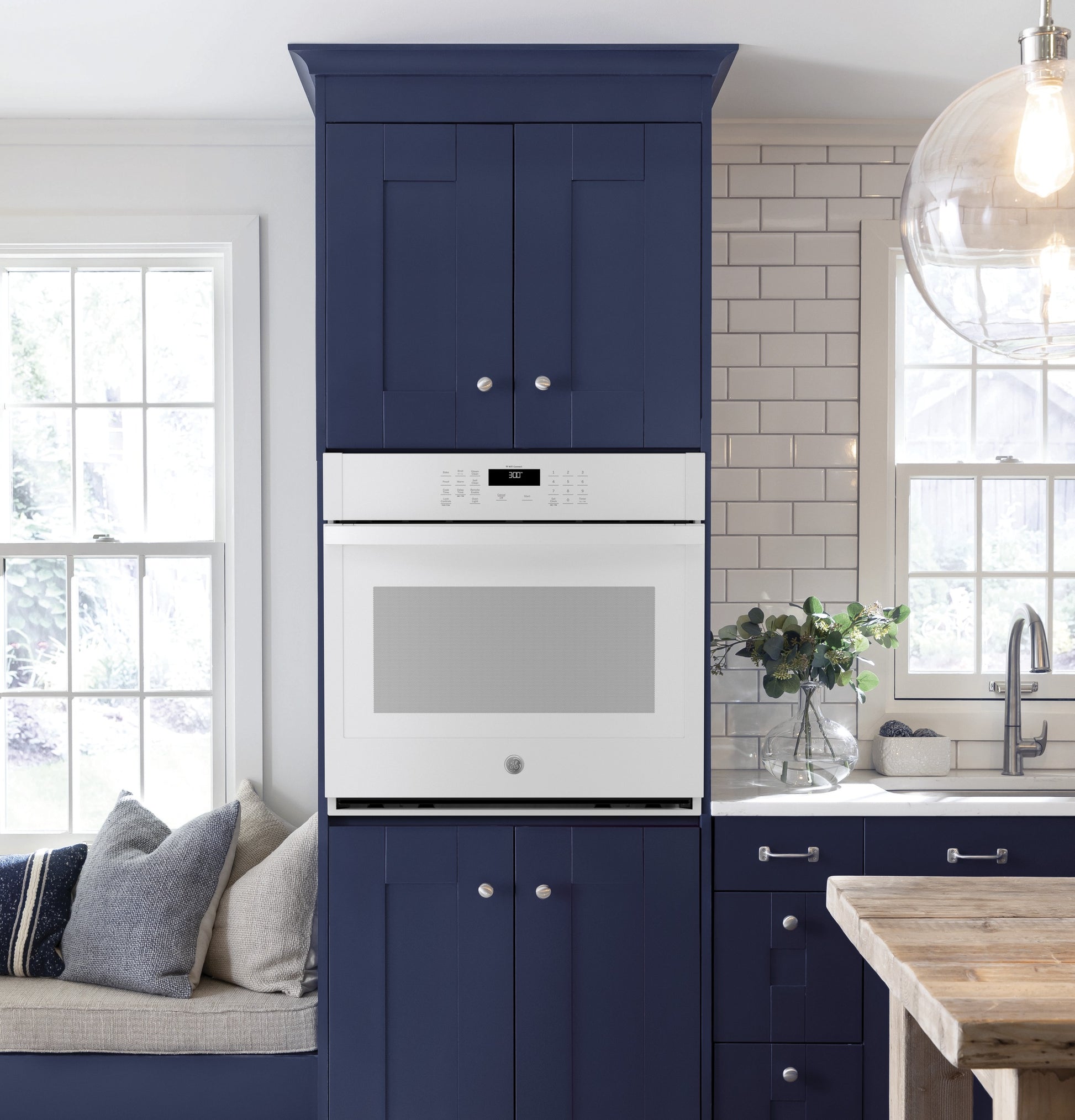 Built-in white single wall oven integrated into navy blue kitchen cabinetry in modern kitchen and appliances collection