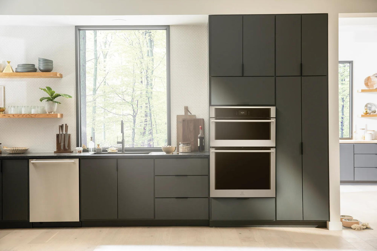Built-in stainless steel wall oven and microwave combo integrated into modern dark gray kitchen cabinetry