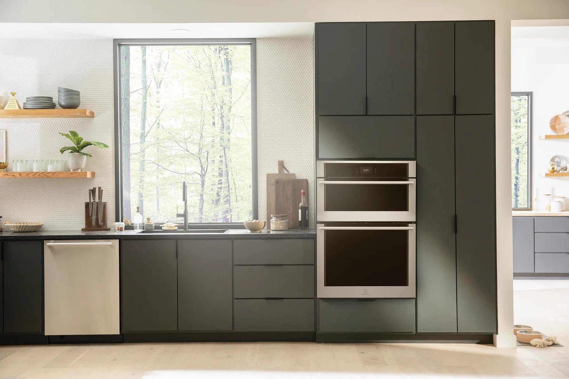 Built-in stainless steel wall oven and microwave combo integrated into modern dark gray kitchen cabinetry