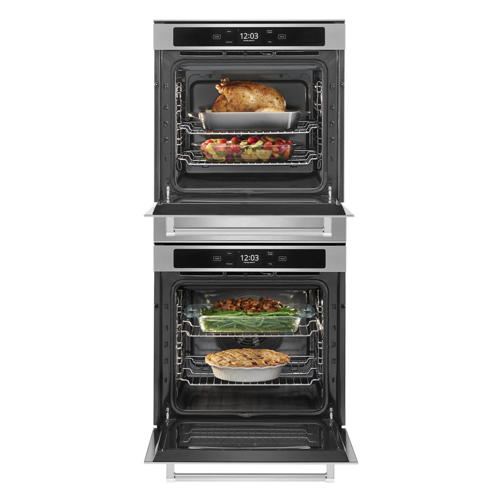 Front view of stainless steel double wall oven with open doors displaying cooked food inside racks