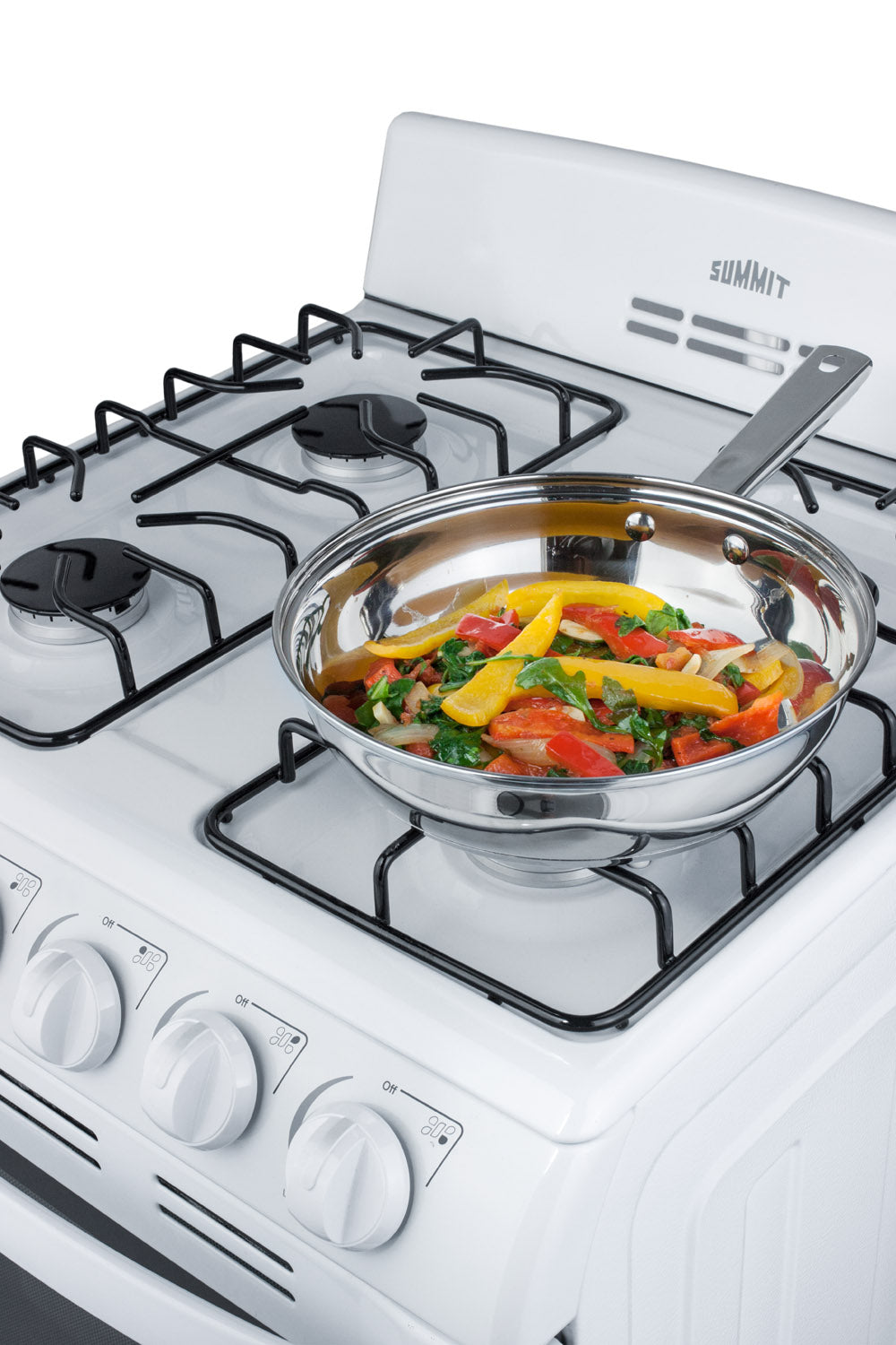 White slim gas range with four burners and stainless steel frying pan cooking colorful vegetable stir-fry