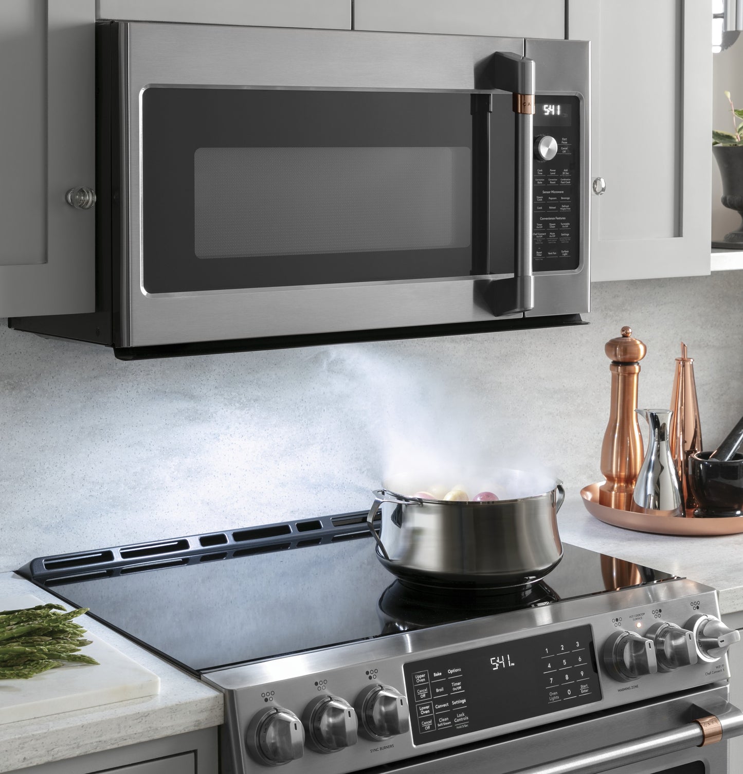 Stainless steel over-the-range microwave with digital controls installed above modern stovetop in kitchen appliances setting