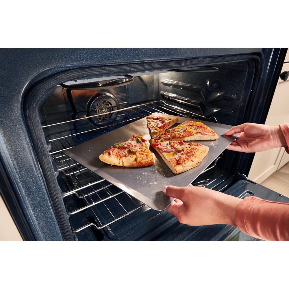 hands placing a pizza on nonstick bakeware inside a 30-inch gas range oven for kitchen and home improvement