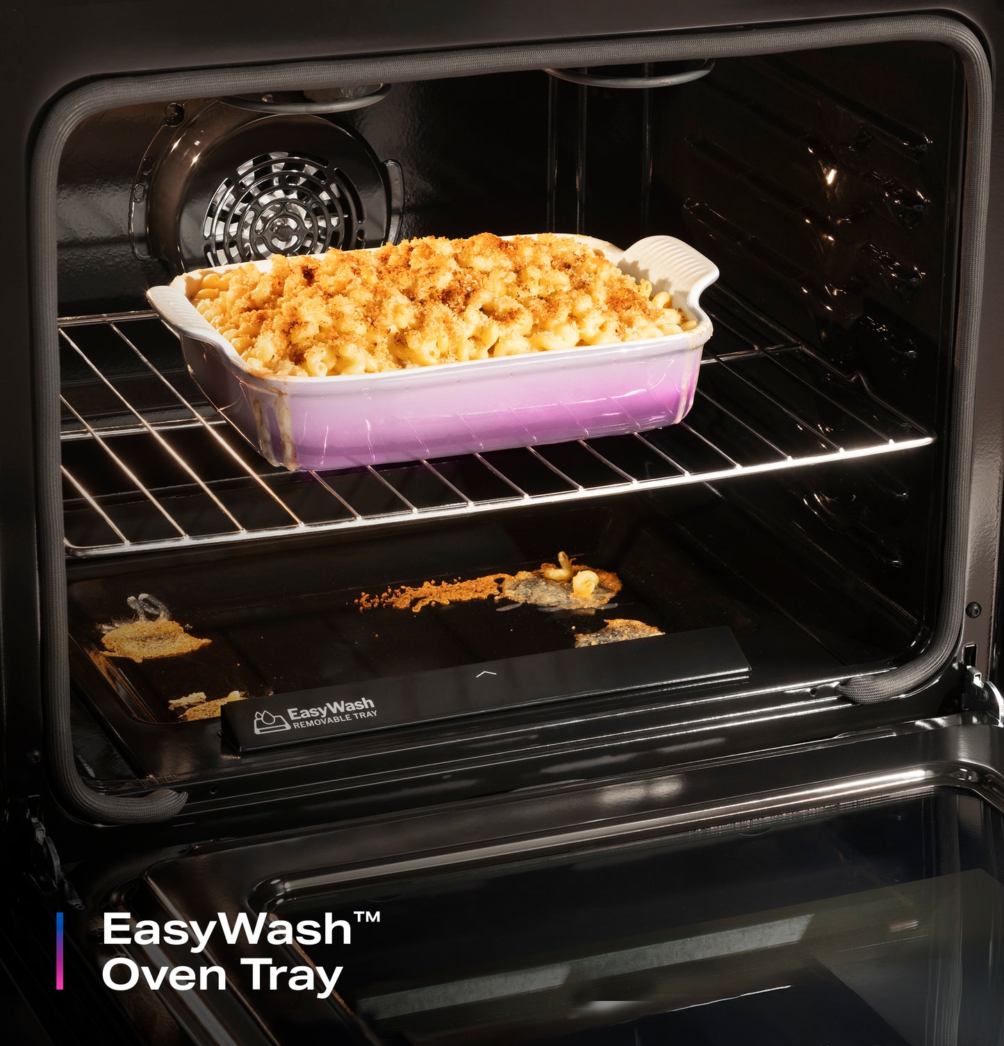Open oven with EasyWash™ removable tray and a casserole dish baking a golden brown dish inside the range for home appliances.