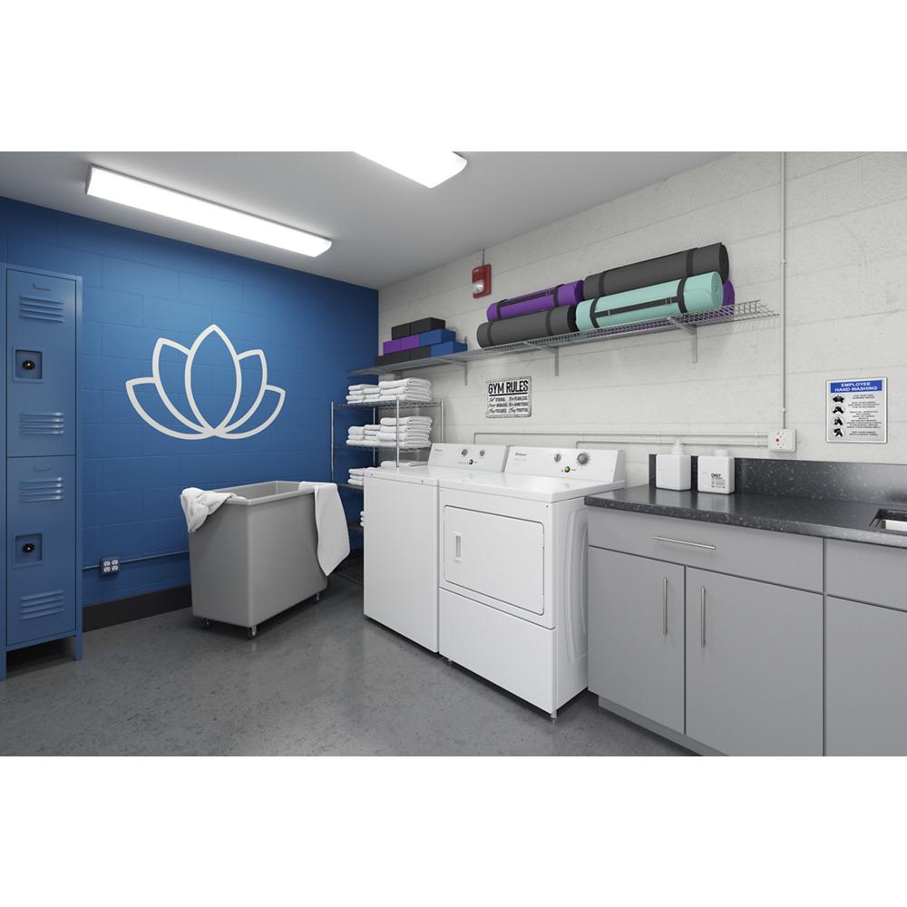 Commercial laundry room setup with top-load washer, dryer, storage lockers, gray cabinets, and floor mat storage in blue and white walls.