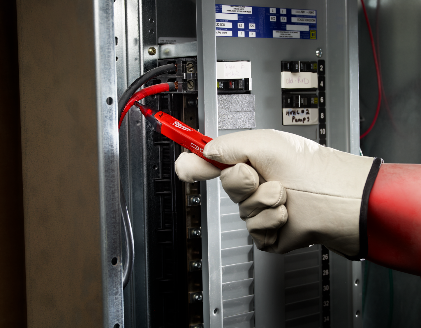 Handheld red Milwaukee LED voltage detector testing wiring inside electrical panel for home improvement tools collections