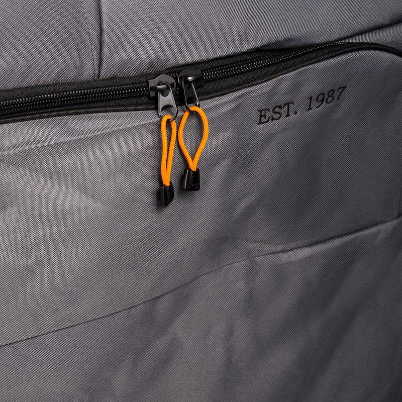 Close-up of heavy-duty gray polyester fabric with black zipper and orange pull cords on an outdoor grill cover accessory.