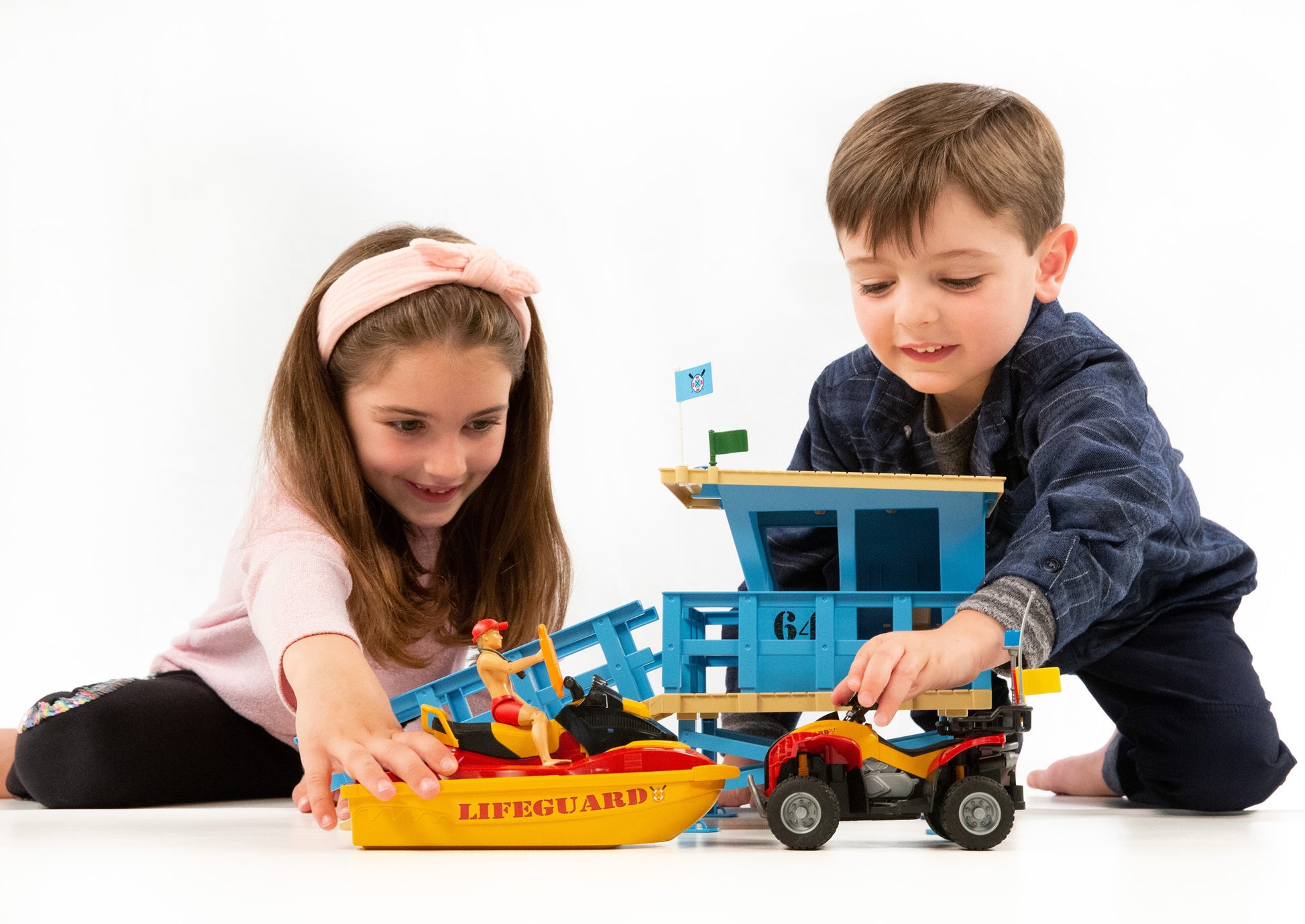 Two children playing with blue lifeguard station, yellow rescue watercraft, and red quad from Bruder Toys collection under $100