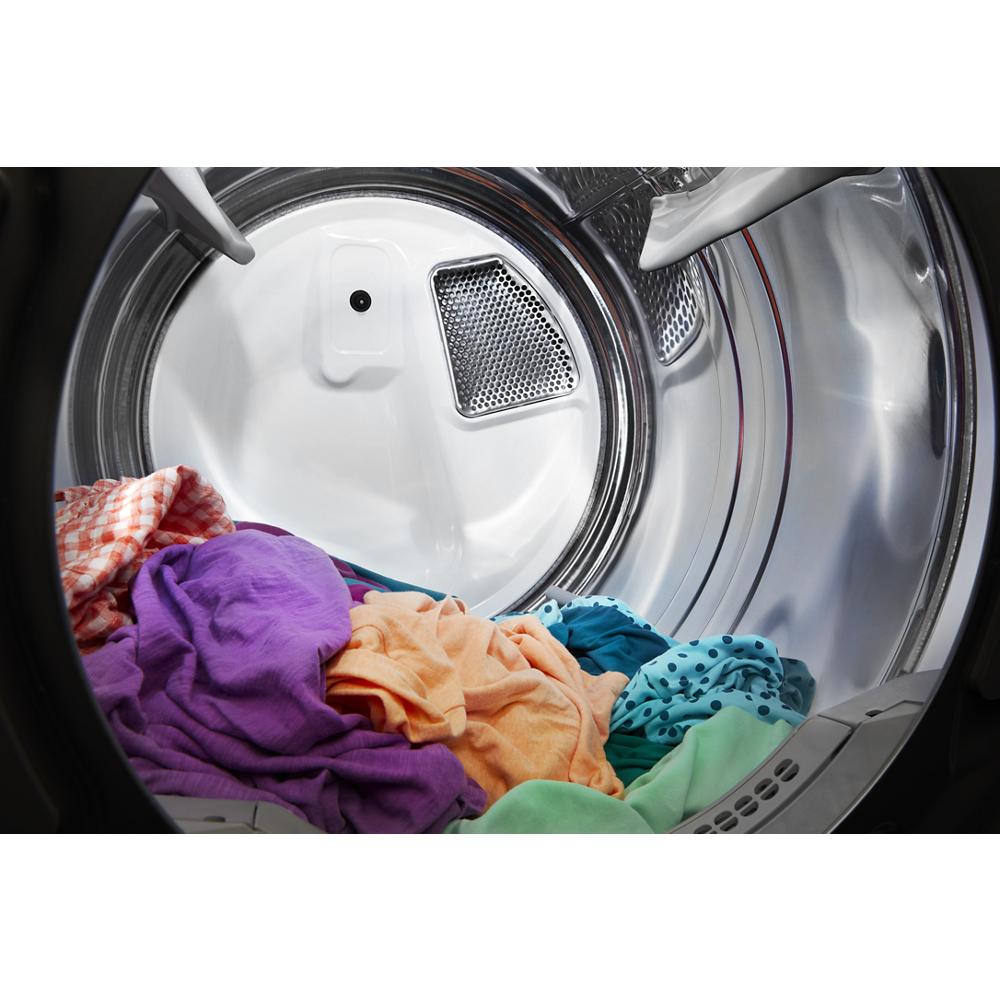 Colorful clothes tumbling inside the stainless steel drum of a front load gas dryer in the Dryers collection