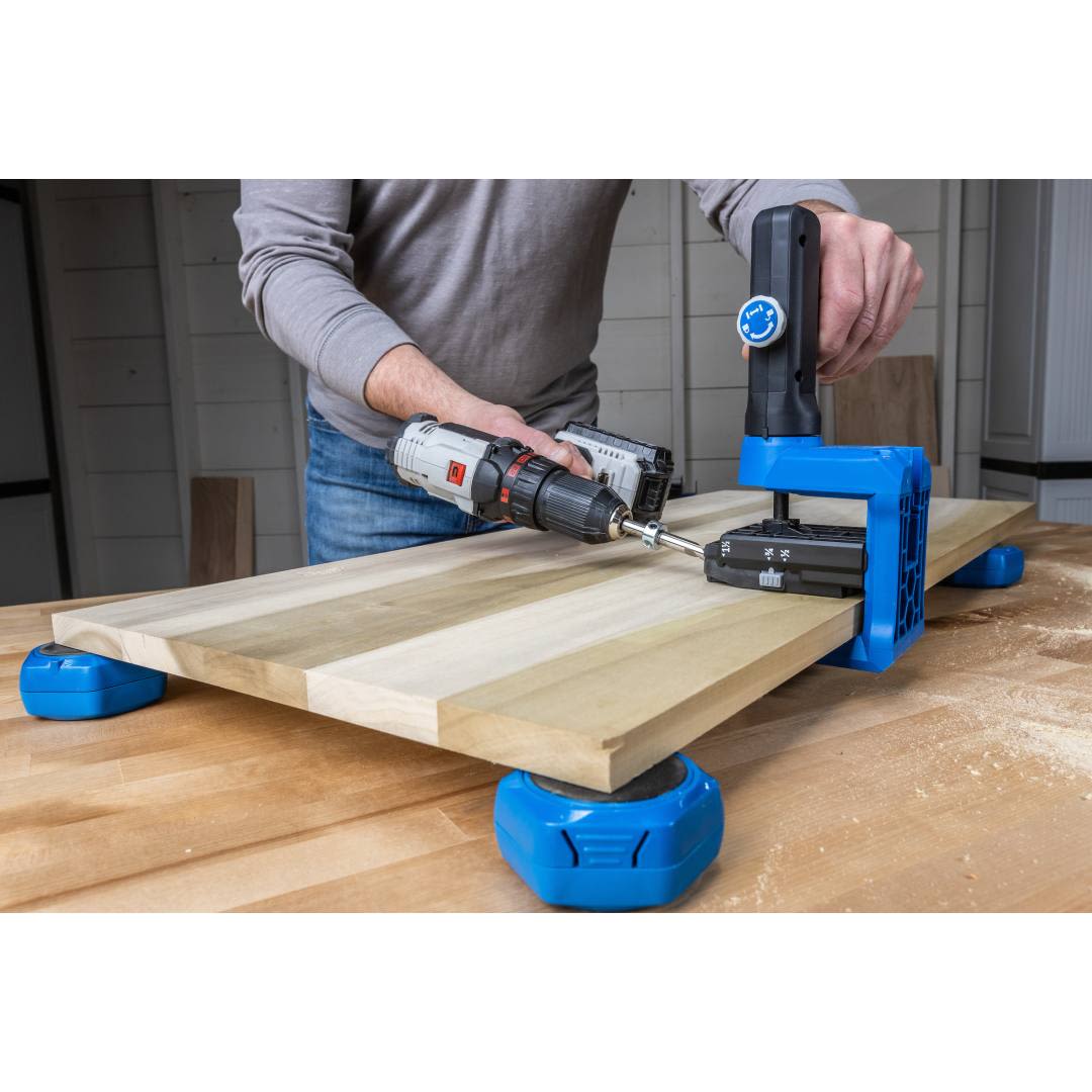 Blue multi-purpose project blocks securing wood panel while a person drills for tools and home improvement tasks