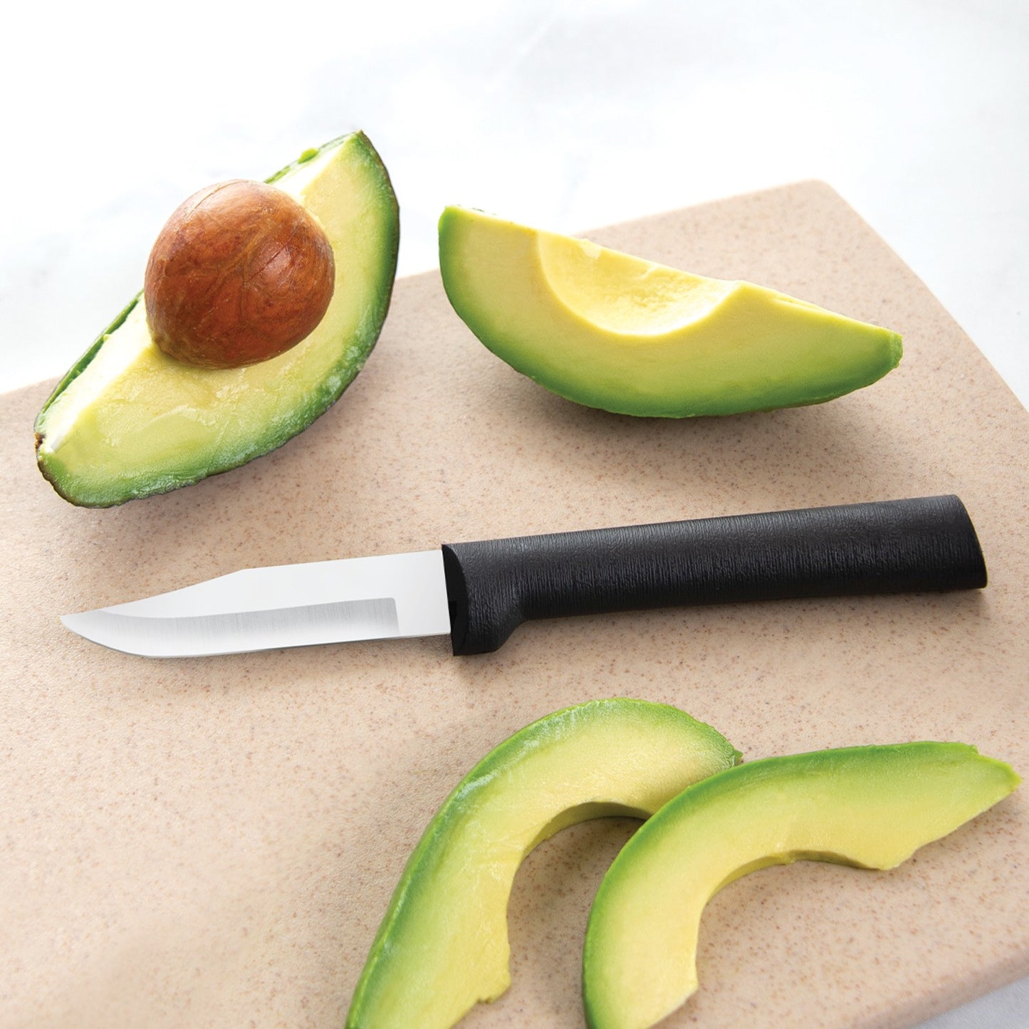 Peeling knife with black handle beside sliced avocado on beige cutting board for precise kitchen prep tasks