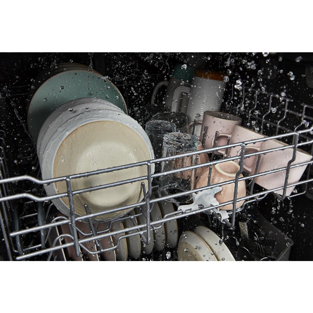 Water spraying over cups, plates, and glasses inside a dishwasher rack in kitchenware appliance collection