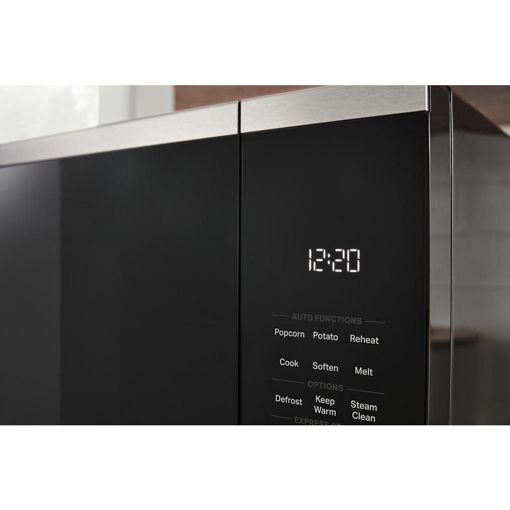 Close-up of black sensor microwave digital display and control panel with auto cook and steam clean options in modern kitchen