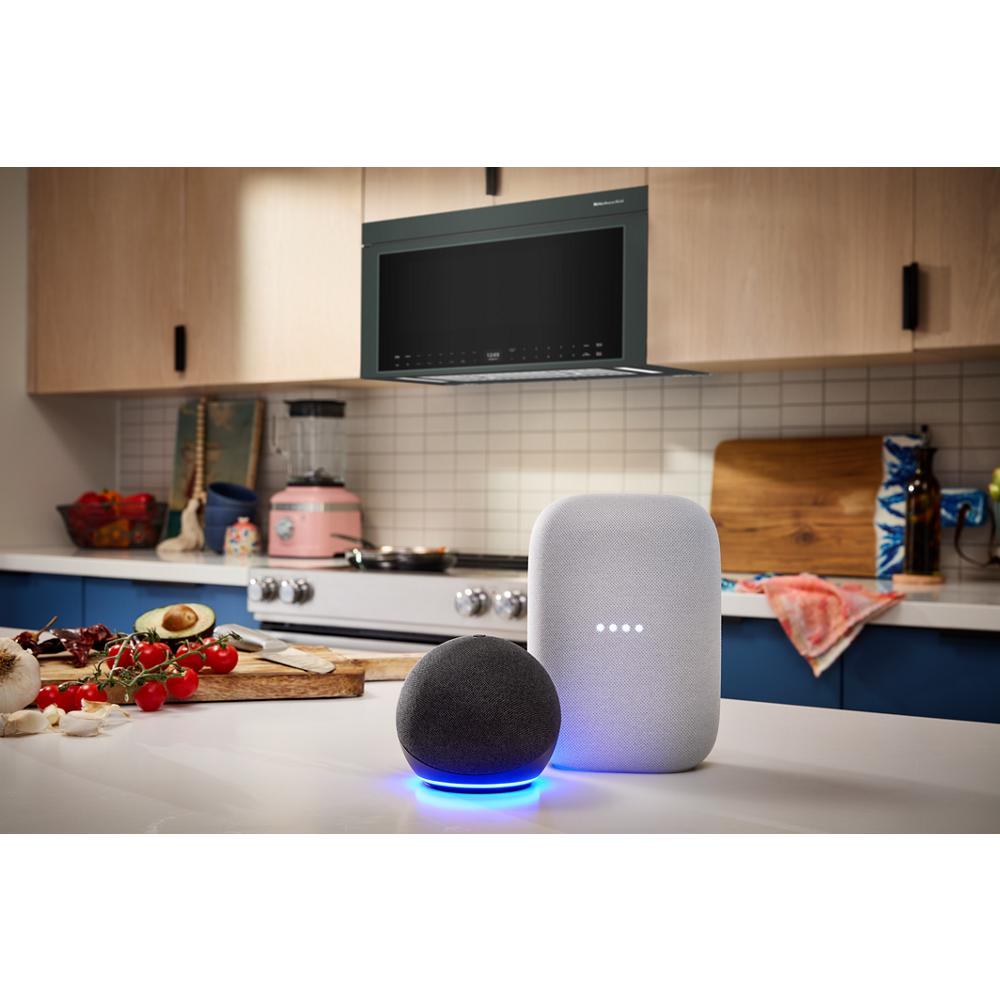 Modern kitchen scene with multifunction over-the-range microwave above stove and smart home assistants on countertop
