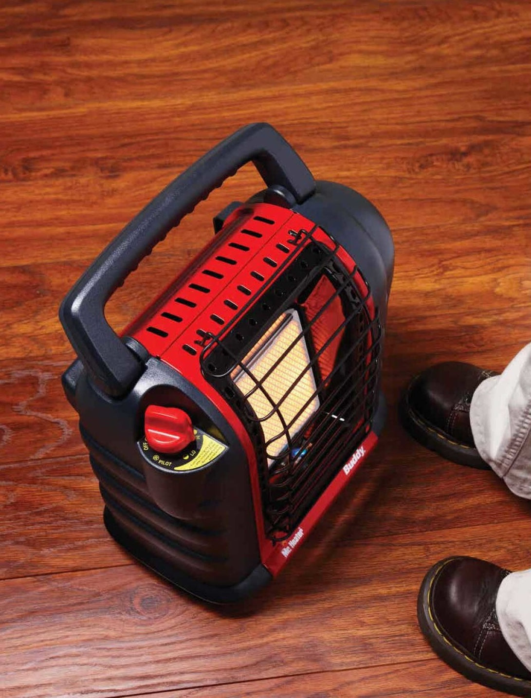 Portable red and black radiant propane heater on wooden floor near person’s feet in Under $100 and All Products collections