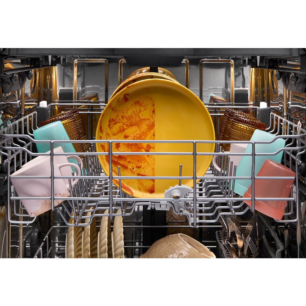 Inside view of dishwasher loaded with dirty colorful dishes, plates, and cups in kitchen appliances collection