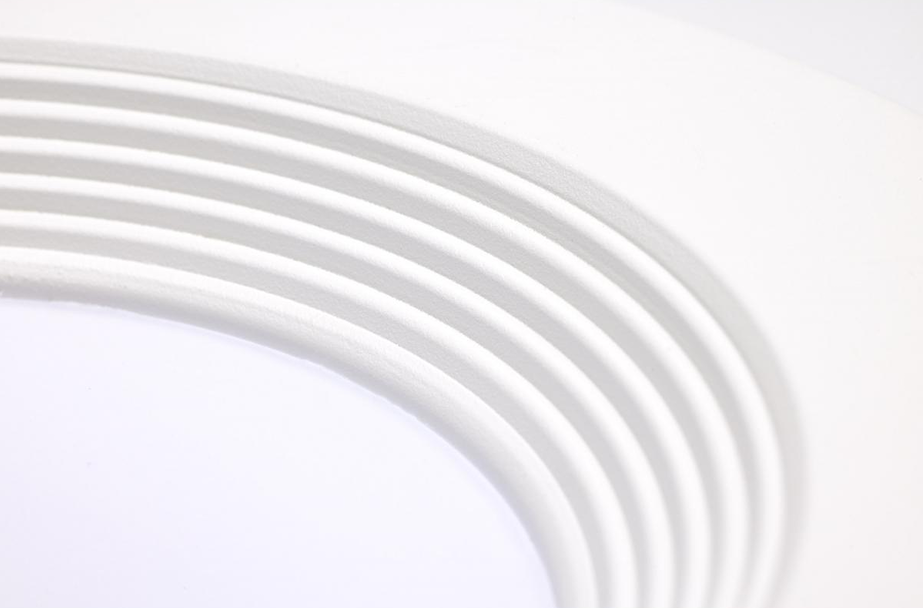 Close-up of round white LED retrofit downlight trim with concentric ridges for lighting and electrical use under $50 category